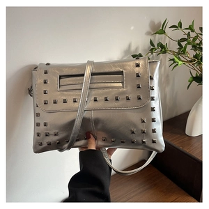 Dettaglio della borsa a tracolla argento metallizzato con borchie a piramide grigio scuro