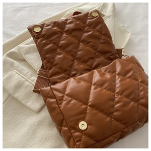 Dettaglio della borsa trapuntata marrone con chiusure magnetiche e trama in pelle