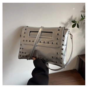 Dettaglio della borsa a tracolla in ecopelle argento con borchie metalliche quadrate grigie