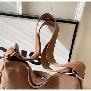 Detail of vintage brown corduroy backpack showing durable fabric and metal buckle