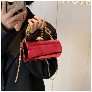 Detail of red acrylic cylinder evening bag with gold chain and decorative pearl clasp
