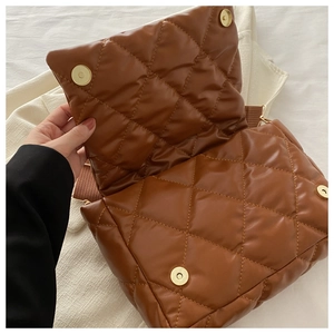 Dettaglio borsa trapuntata marrone in similpelle con chiusura magnetica e tracolla