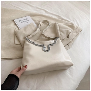 Close-up of cream soft leather tote bag with silver chain detail and adjustable strap