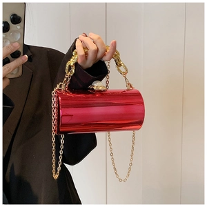 Detail of red metallic cylindrical clutch bag with gold chain and large pearl clasp