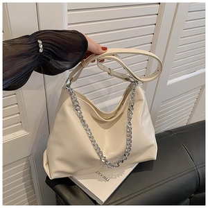 Detail of a creamy hobo bag featuring glossy wrinkled leather and silver chain strap