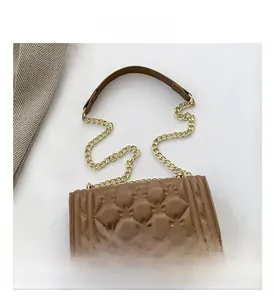 Close-up of brown quilted faux leather handbag with golden metal chain strap detail