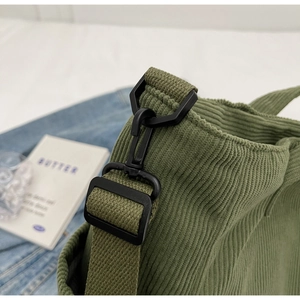 Detail of army green corduroy bag showing the adjustable strap and durable plastic buckle