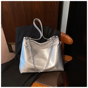 Detailed macro view of silver metallic textured faux leather tote bag with chunky chain