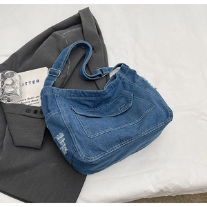 Dettaglio della borsa a tracolla in denim blu con trama lavata e tracolla regolabile