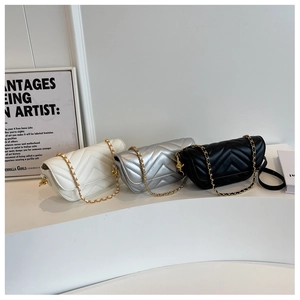 Detailed trio of V-shaped chevron quilted crossbody bags in white, silver, and black