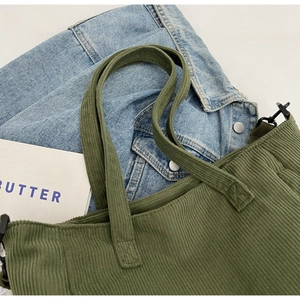 Detail of army green corduroy tote bag texture with metal D-rings and casual props