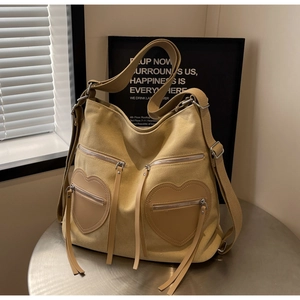 Detail view of khaki corduroy backpack featuring two unique heart-shaped front pockets