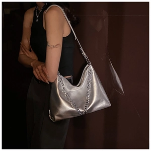Close-up of metallic silver hobo bag featuring a chunky chain and soft leather texture