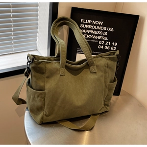 Detail of army green corduroy tote bag showing side pocket and adjustable strap