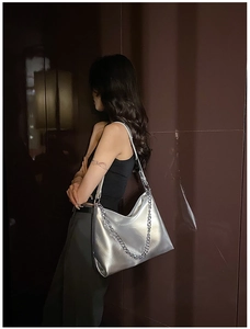 Detail of silver metallic hobo bag with pleated texture and stylish silver chain strap