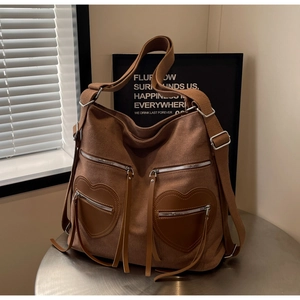 Detail of vintage brown corduroy backpack with leather heart pockets and wide cotton strap