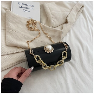 Detail of cylinder evening bag with mirror finish, large pearl and gold chain strap