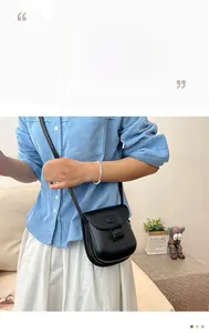 Detailed view of a black pleated crossbody bag worn by a model in a casual outfit