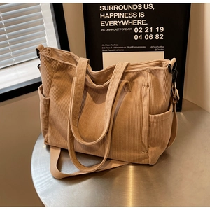 Close-up of khaki corduroy tote bag with side pockets on a metal table setting