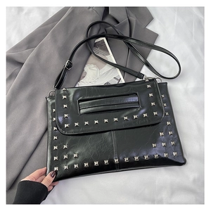 Dettaglio borsa vintage in pelle PU nera con borchie argentate e tracolla regolabile