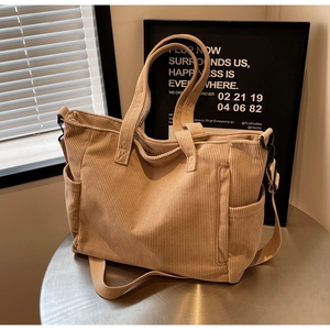 Detailed texture of corduroy tote bag with side pocket and canvas shoulder strap