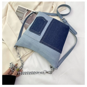 Detail of contrasting denim crossbody bag with adjustable strap and silver chain link