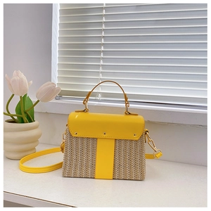 Detailansicht der gelben Strohtasche mit Textur, Goldnieten und Umhängeriemen