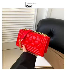 Detailed view of red quilted leather surface and gold chain strap of the fashion handbag