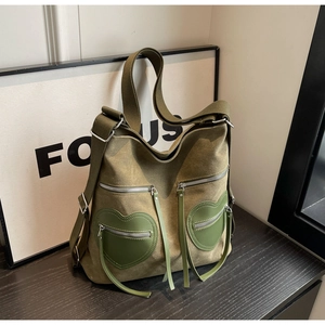 Detailed macro view of olive green corduroy backpack with twin green heart-shaped front pockets