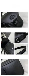 Detailed close-up of textured black leather crossbody bag showing magnetic closure and seams