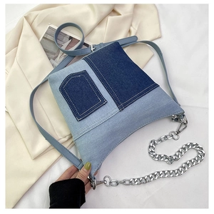 Close-up detail of patchwork denim bucket bag with adjustable leather strap and pocket