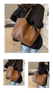 Detail of a brown lychee pattern leather tote bag with a minimalist metal bar accent