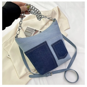 Detailed close-up of blue denim patchwork bucket bag with silver chain strap