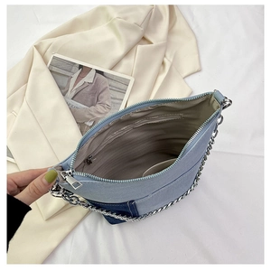 Internal view of denim patchwork shoulder bag with fabric lining and zipper pocket