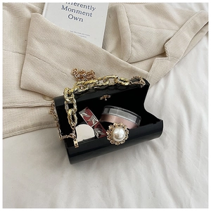 Internal view of acrylic cylinder clutch with pearl clasp showing lipstick storage space