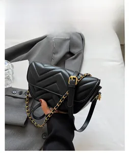 Detail of black crossbody bag featuring V-quilted texture and gold chain strap
