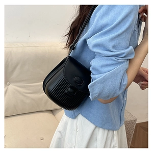 Detail of black crossbody bag with vertical striped pleats and Fashion embossed texture