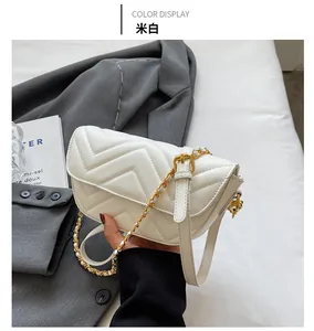 Close-up of off-white chevron quilted bag featuring gold buckle and elegant chain strap