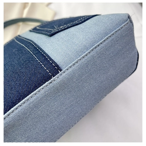Macro shot of patchwork denim bucket bag showing stitching details and base construction