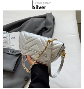 Detail shot of silver quilted leather crossbody bag with adjustable gold chain strap