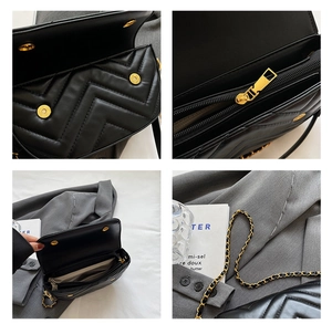 Detail view of black quilted crossbody bag with gold hardware and chain strap