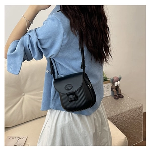 Black vertical striped square crossbody bag in matte PU leather shown on a shoulder