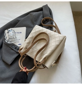 Top view of cream bucket bag with brown handles and elegant quilted stitch texture