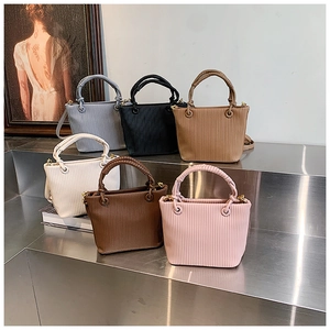 Vertical pleated bucket bags in multiple colors displayed on a metallic tiered stand