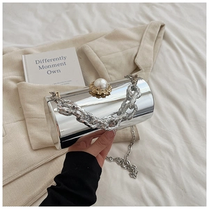 Detailed view of silver mirror cylindrical bag with pearl clasp and dual chain straps