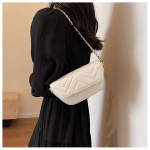Detail of white V-quilted faux leather crossbody bag with elegant gold chain strap for women