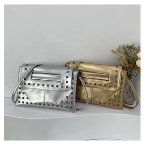 Dettaglio delle borse a busta argento e oro con borchie metalliche quadrate scure