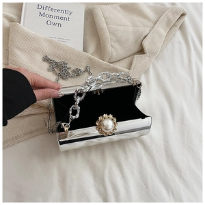 Silver metallic clutch box bag with pearl flower clasp and black velvet lining shown open
