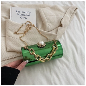 Detail of green acrylic cylinder bag with pearl rhinestone clasp and gold chain strap