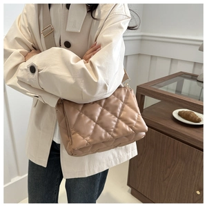 Vista dettagliata della borsa a tracolla trapuntata beige con ampia fascia regolabile